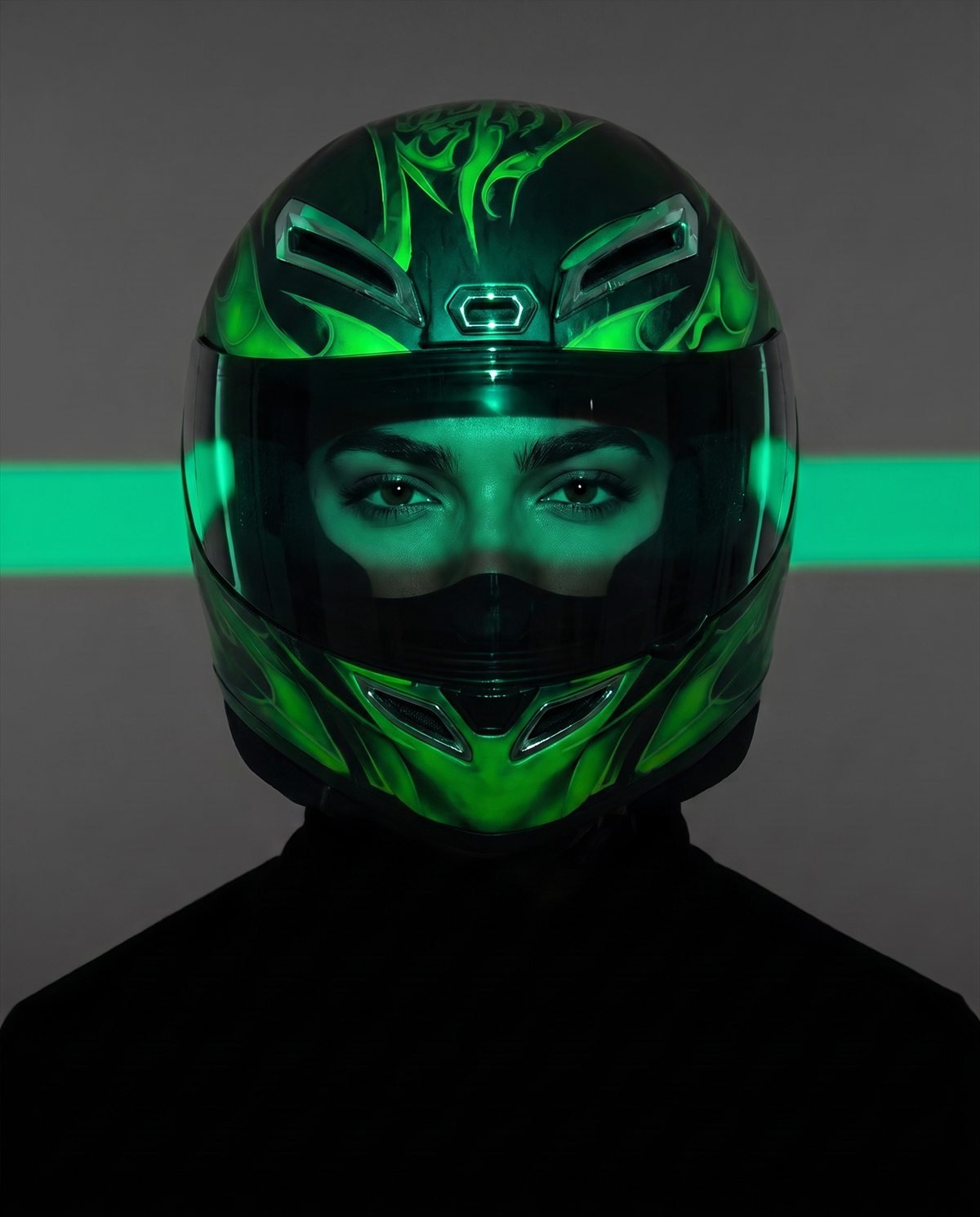 Motociclista de frente con casco verde neón, iluminada por una franja de luz verde.