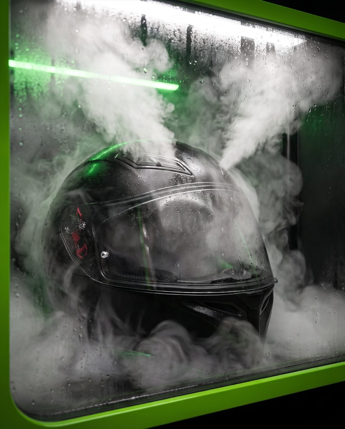 Casco integral negro dentro de la cabina MotoFresh, envuelto en vapor y con la barra de luz UV-C encendida en verde.